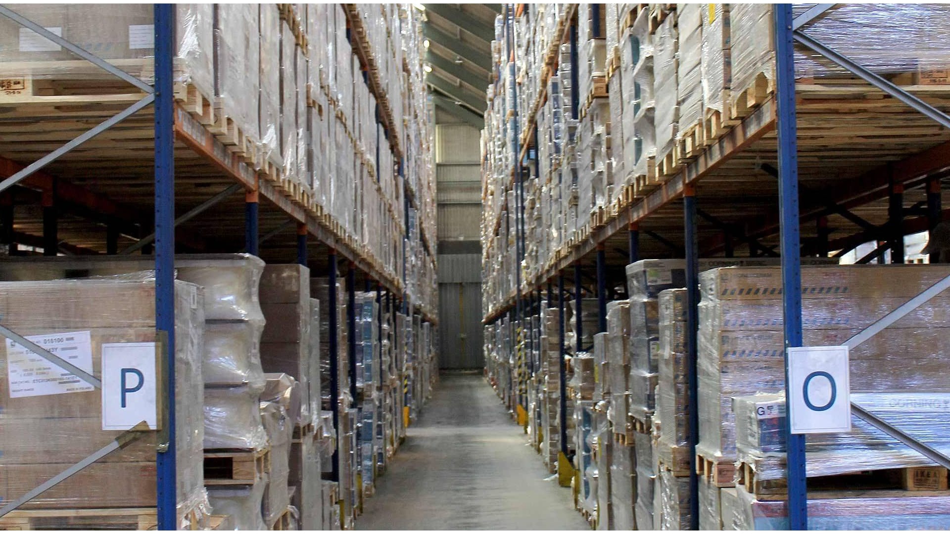 Image of warehouse with wrapped up boxes on pallets with multiple shelves